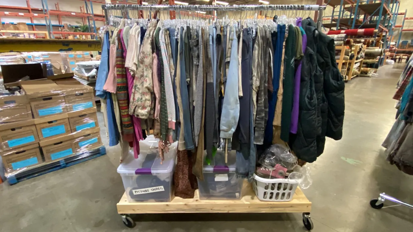 MOBILE WARDROBE RACK FILLED WITH ASSORTED CLOTHING