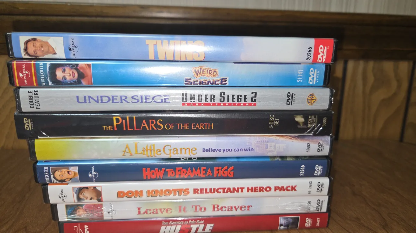 A LOT OF DVD'S INCLUDING TWINS, WEIRD SCIENCE, THE PILLARS OF THE EARTH, A LITTLE GAME, LEAVE IT TO
