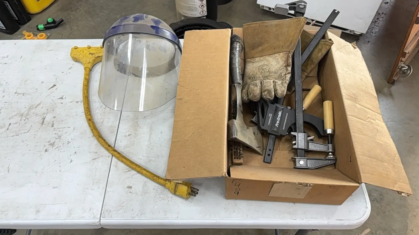 Clamps, axe, face shield, and work gloves
