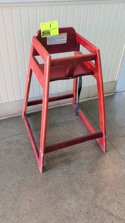 Wooden high chair. Features wood construction in a reddish-brown finish, safety restraint strap, and stackable frame design. 21" floor to seat height.
