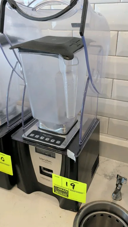 Blendtec Connoisseur 825 commercial blender. Features sound enclosure hood, digital push-button controls, and blending jar with lid.