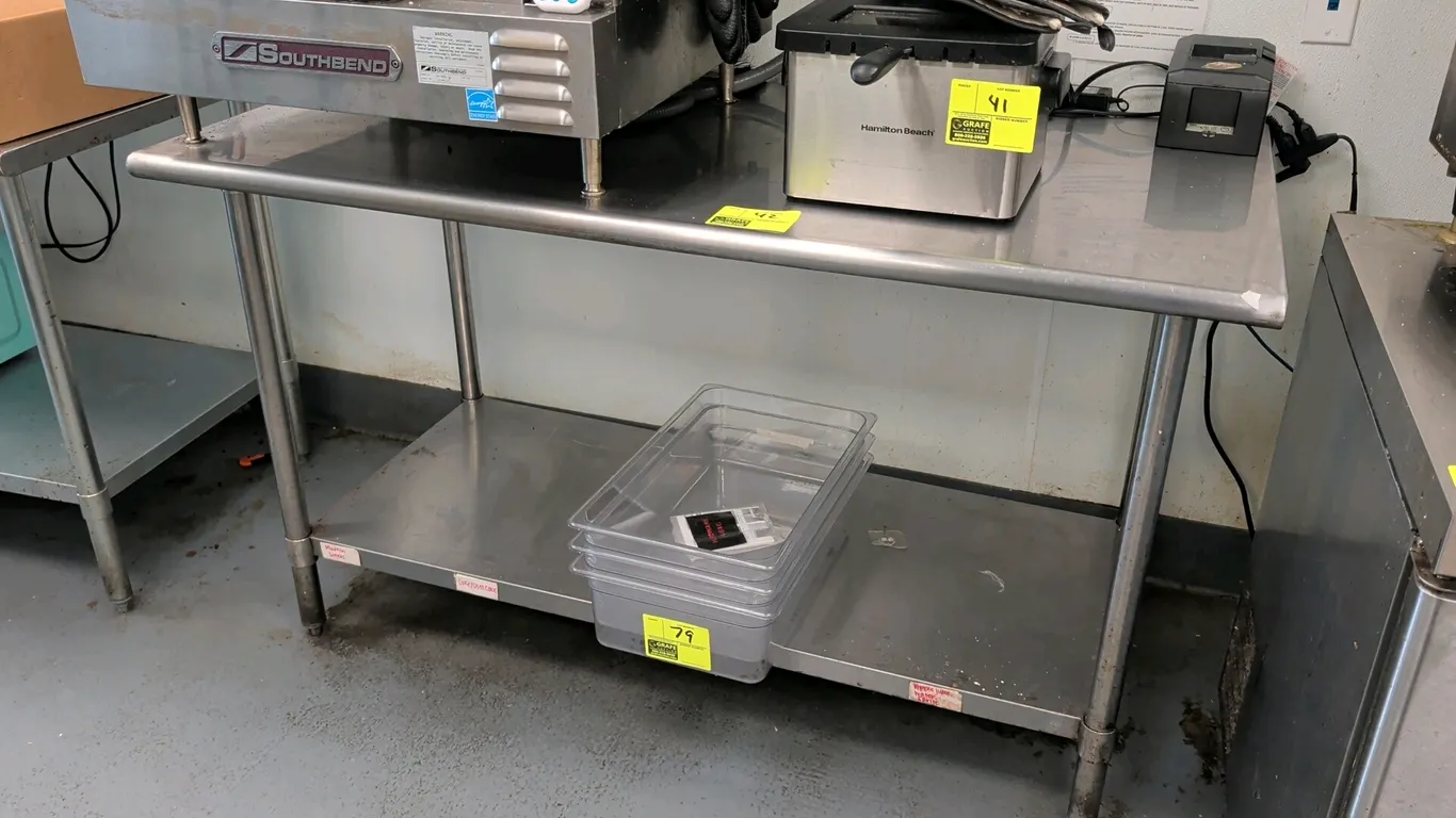 Stainless steel work table. Features a stainless steel top and stainless steel undershelf. Dimensions: 60" x 30". Mounted on tubular legs with adjusta