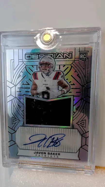 A Javon Baker Rookie Autograph Memorabilia Card. (Panini, 2024) A 2024 Panini Obsidian Football rookie jersey autograph card of New England Patriots r