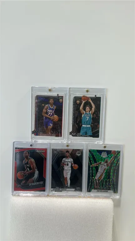 A Collection of Basketball Trading Cards. (Panini/Topps, 2024-25) Includes Zion Williamson Mosaic Elevate, De'Aaron Fox Prizm Black numbered 142/299,