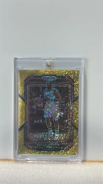A 2022-23 Panini Prizm Kawhi Leonard Gold Shimmer Prizm Trading Card. (Panini, 2022-23) A Panini Prizm Basketball card featuring Kawhi Leonard of the