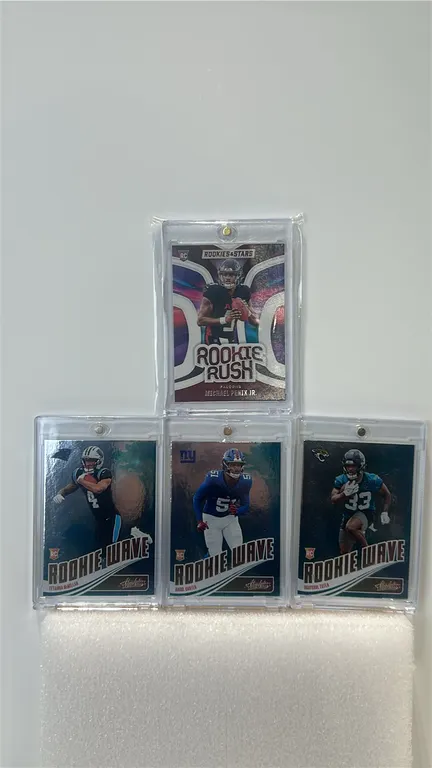 A Collection of Four Panini Rookie Football Cards. (Panini) Includes a Michael Penix Jr. Rookies & Stars Rookie Rush insert, alongside Tetairoa McMill