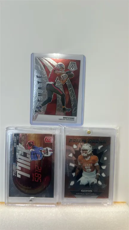 A 3-Piece Panini Football Trading Card Collection. (Panini, 2023-2024) Includes a 2024 Mosaic Mike Evans (No. 19), a 2023 Donruss Elite James Cook Ful