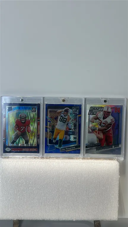 A Collection of Panini Football Cards. (Panini, 2015-2024) Includes a 2024 Donruss Optic Bucky Irving #216 Rated Rookie, 2023 Donruss Optic Luke Musgr