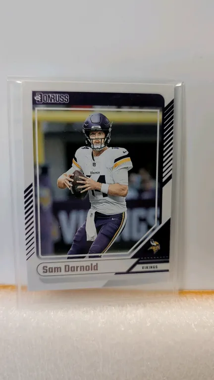 A 2024 Panini Donruss Sam Darnold No. 180 Trading Card. (Panini, 2024) Features quarterback Sam Darnold in a Minnesota Vikings uniform, with reverse p