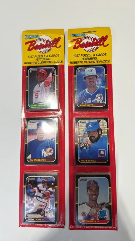 A Pair of 1987 Donruss Baseball Sealed Rack Packs. (Donruss, 1987) Factory-sealed rack packs containing 75 cards and 18 Roberto Clemente puzzle pieces