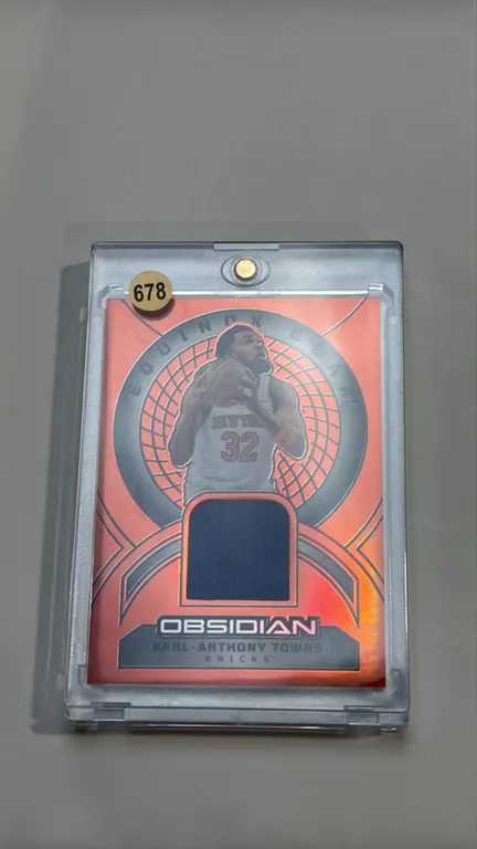 A Karl-Anthony Towns Equinox Gear Game-Worn Material Card. (Panini, 2024-25) A 2024-25 Panini Obsidian Basketball card (No. EG-KAT) featuring New York