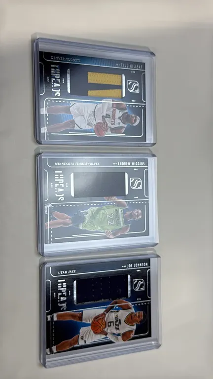 A Collection of 2024-25 Panini Silhouette Basketball Threads Trading Cards. (Panini, 2024-25) A lot of (3) cards with game-worn/used swatches: Andrew