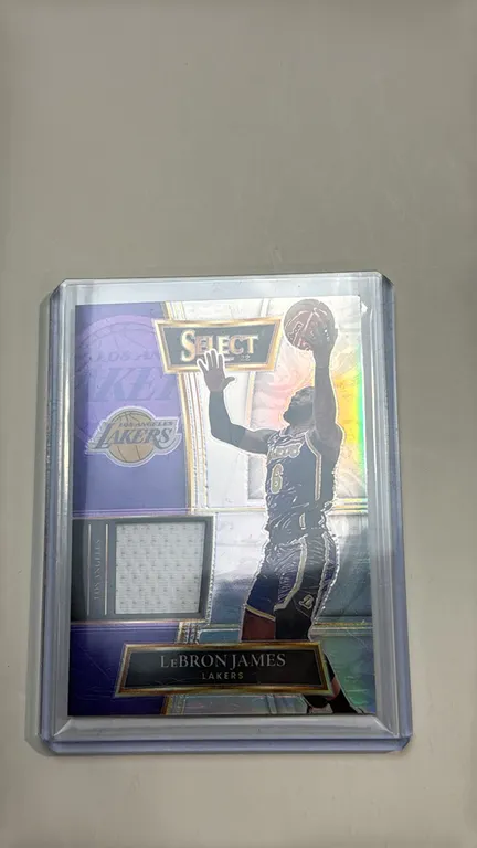 A 2021-22 Panini Select LeBron James Jersey Card. (Panini, 2021-22) A Panini Select Basketball card No. SS-LBJ featuring LeBron James of the Los Angel