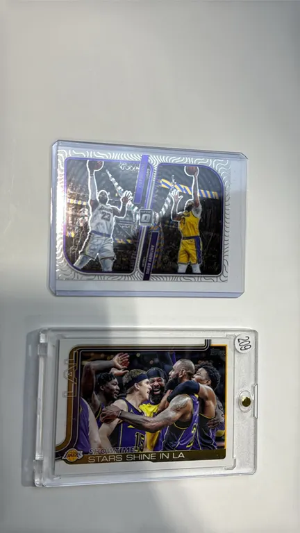 A Pair of Los Angeles Lakers Basketball Cards. (Topps/Panini, 2023-2025) A 2-card lot featuring a 2025 Topps Flagship #293 'Showtime! Stars Shine in L
