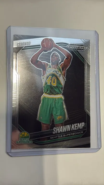 A Shawn Kemp Panini Prizm Black Trading Card. (Panini, 2024-25) A Panini Prizm Black Legends series basketball card, No. 299, featuring Shawn Kemp wit