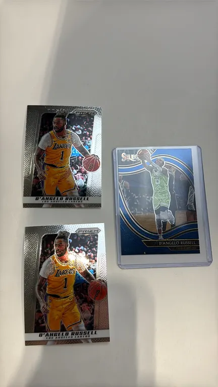 A D'Angelo Russell Basketball Card Lot. (Panini, 2020-2025) A collection of (3) trading cards including (1) 2020-21 Panini Select card (Minnesota Timb