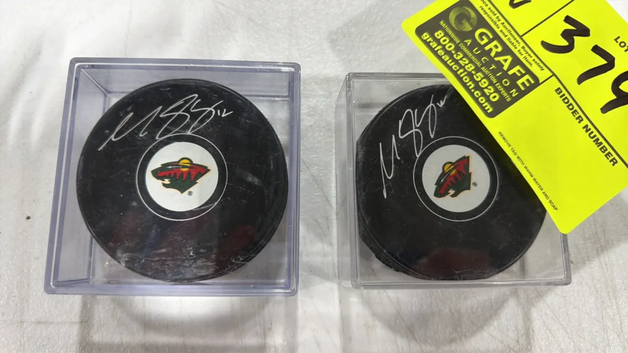 A Pair of Matt Boldy Autographed Minnesota Wild Hockey Pucks. Features silver-tone signatures with player number 12 and Minnesota Wild team logos. Eac
