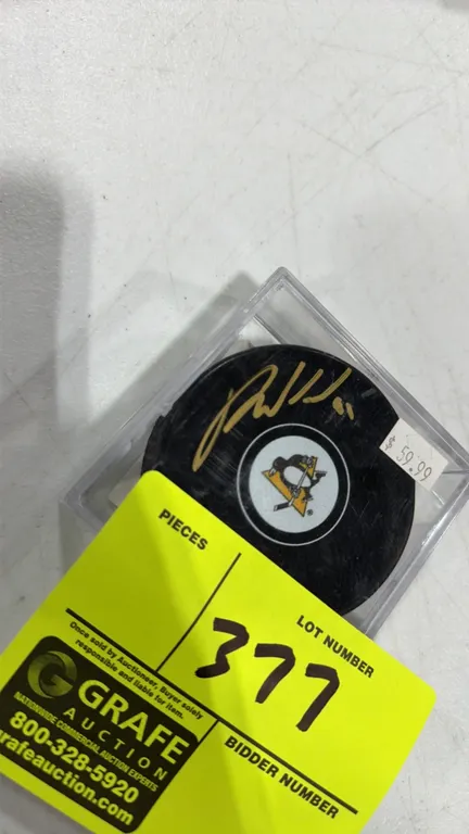 An Autographed Pittsburgh Penguins Hockey Puck. (Total Sports Enterprises) A Pittsburgh Penguins hockey puck autographed in gold paint pen. Includes a