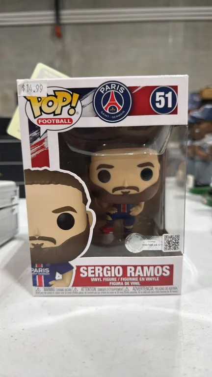 A Funko Pop! Football Sergio Ramos Vinyl Figure #51. (Funko) Featuring Paris Saint-Germain player Sergio Ramos in his PSG home kit with a football. Re