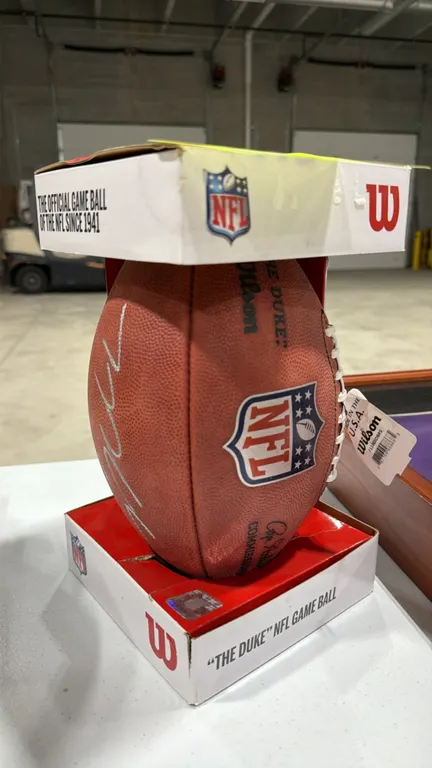 A Wilson "The Duke" NFL Official Game Football. Features an unidentified signature in silver-tone paint marker on pebbled leather. Handcrafted in the