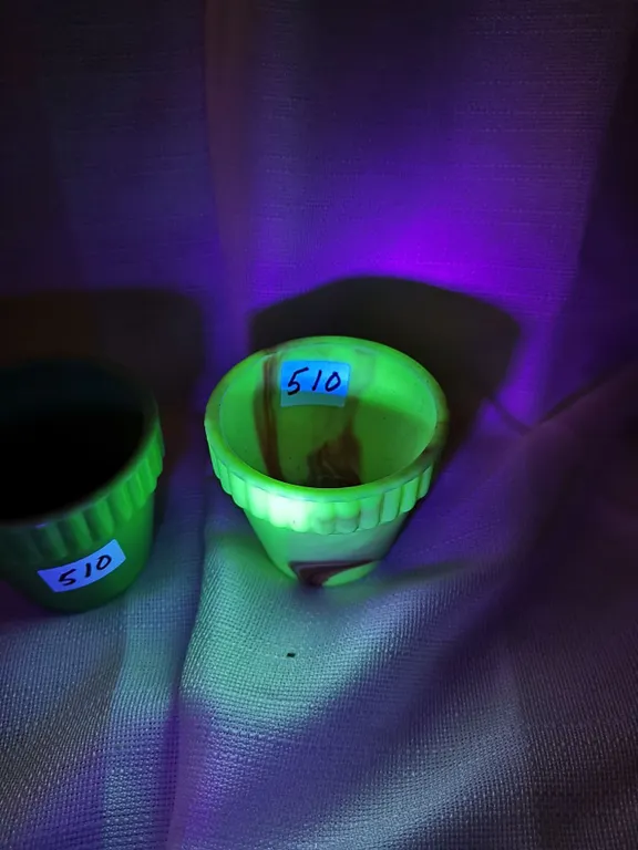 Two antique plant holders, one glows