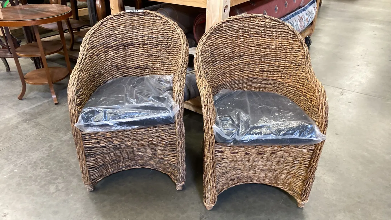 PAIR OF WOVEN RATTAN CHAIRS WITH BLACK UPHOLSTERED CUSHIONS