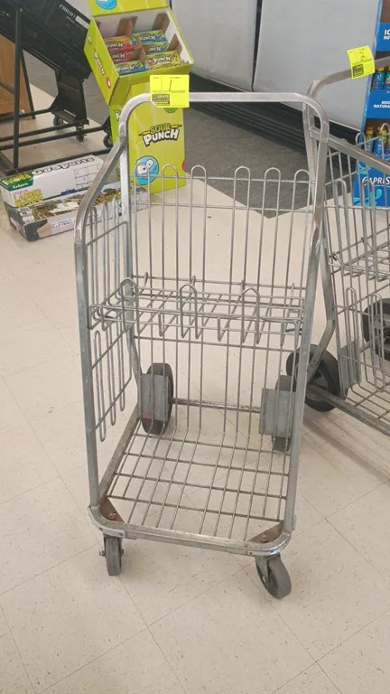 Metal parking lot grocery carryout cart. Features tubular frame, wire basket construction with an upper folding wire shelf, integrated push handle, an