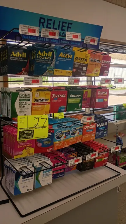 Metal countertop merchandiser display rack. Features 4 tiers of wire hanging hooks, price label channels, and top header sign. Includes displayed conv