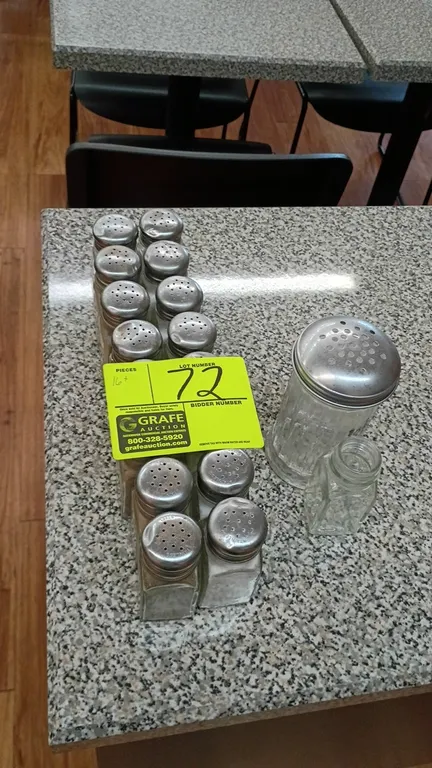 Assorted glass salt and pepper shakers. Features clear glass paneled bodies with perforated metal screw-on caps. Includes tabletop shakers, a large co