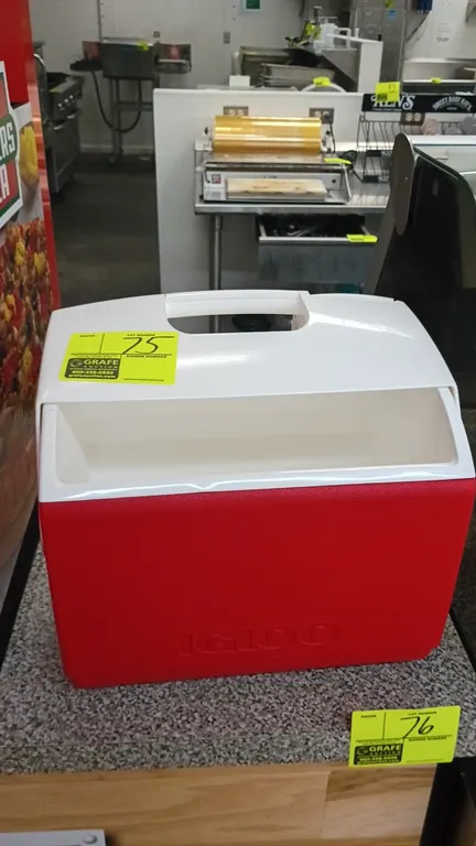 Igloo lunch box cooler. Features red and white molded plastic construction with top grab handle and tent-top swivel lid.