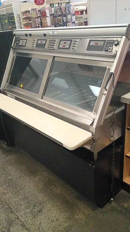 Henny Penny HMR-104 heated merchandiser. Features curved front glass, sliding rear service doors, independent digital temperature controls, and rear p