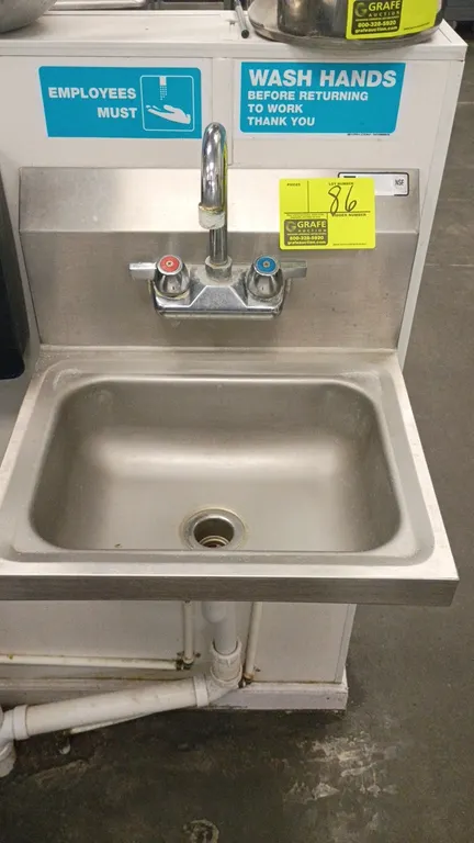 Stainless steel wall-mount hand wash sink. Features integrated backsplash, gooseneck faucet with dual controls, and drain basket. 17" x 15" x 10".