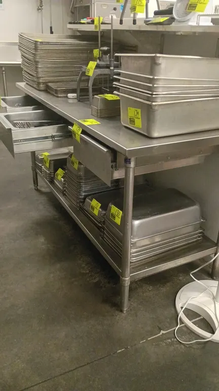 Stainless steel prep table. Features 3 under-counter drawers and a lower undershelf. 72"L x 30"W x 41"H. Mounted on tubular legs with adjustable bulle