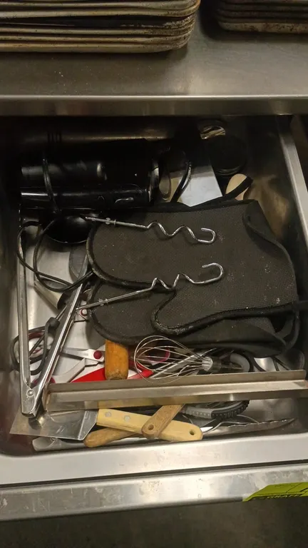Assorted kitchen utensils and electric hand mixer lot. Includes corded electric hand mixer with dough hook attachments, stainless steel tongs, whisk,