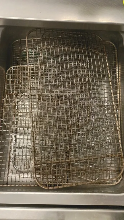 Assorted wire baking and cooling racks. Features wire mesh grid construction with integrated support feet. Drawer, table, and background items not inc