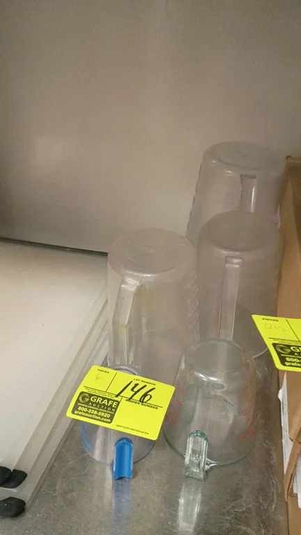 Assorted measuring cups. Includes clear plastic and glass measuring cups and pitchers in assorted sizes with integrated handles and measurement markin