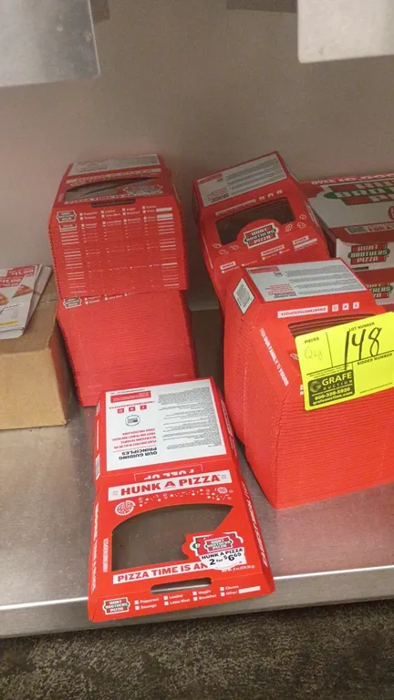 Hunt Brothers Pizza boxes and packaging lot. Includes stacks of Hunk A Pizza single-slice window boxes and whole pizza boxes.