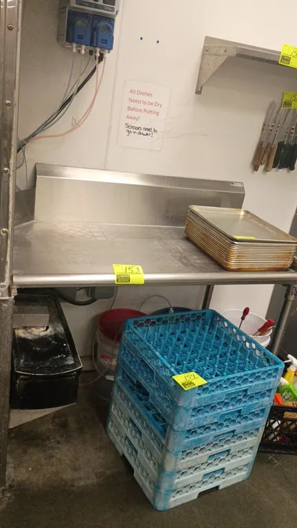 Stainless steel work table. Features an integrated rear backsplash, side splash, and stainless steel tubular legs with adjustable bullet feet. Dimensi
