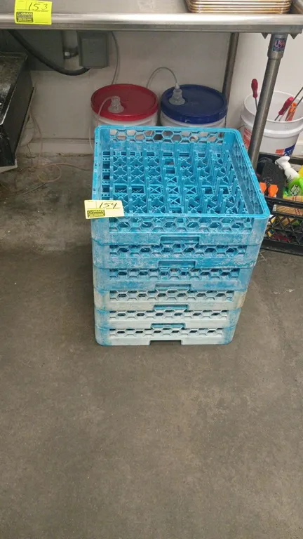 Commercial dishwasher peg racks. Features blue molded plastic construction with internal peg layout and integrated side handles.