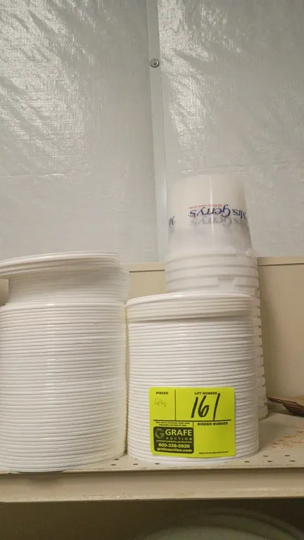 Assorted plastic lids and food containers. Includes stacked plastic lids and translucent food service containers.