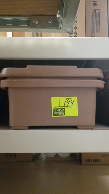 Cambro insulated food transport carrier. Features brown polyethylene construction, top-loading lid with secure latches, and molded-in handles.