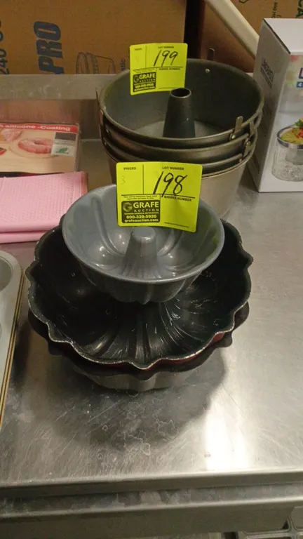 Assorted Bundt cake pans. Features fluted tube baking designs in various sizes and finishes.