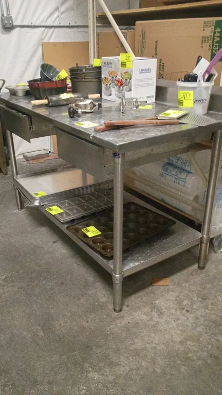 Stainless steel prep table. Features (2) drawers, an undershelf, a rear backsplash, and adjustable bullet feet. 60"L x 30"W x 40"H. Contents not inclu