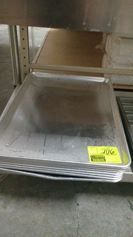 Aluminum baking sheet pans. Features wire-reinforced rolled rims. Note: One pan has a bent rim and bottom.