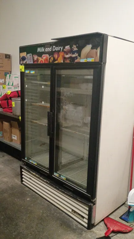 True GDM-49 2-door glass merchandiser refrigerator. Features double glass swing doors, illuminated top sign panel, adjustable wire shelving, interior