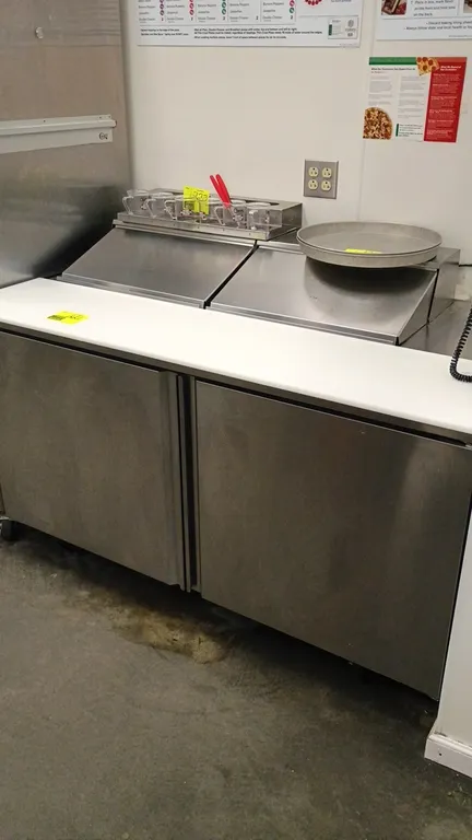 Delfield 4460NP-12-3339 refrigerated prep table. Features stainless steel construction, 2 solid doors, full-length cutting board, dual pan rail hood c