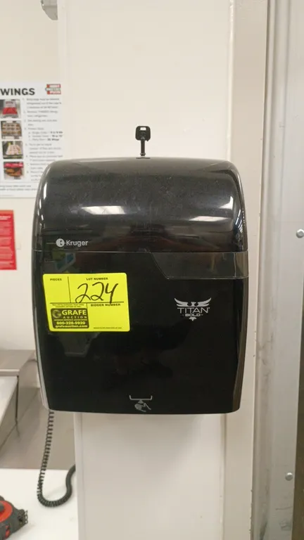 Kruger Titan Bold roll paper towel dispenser. Features black plastic construction and top locking mechanism with key included. Wall mounted.