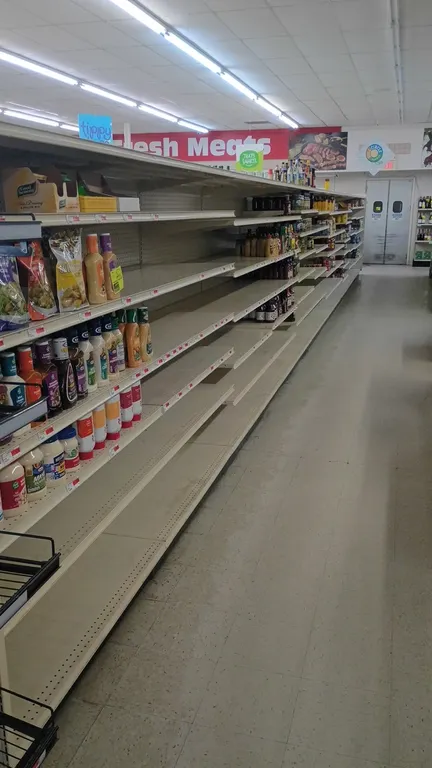 104'L of Lozier gondola shelving. Features 72"H uprights with 22"D base shelves, multi-tier adjustable metal shelving, and pegboard backing. Contents