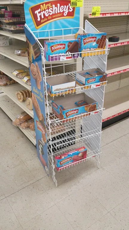 Mrs. Freshley's 5-tier wire display rack. Features white wire construction and branded side and top signage graphics. Includes contents. 19"L x 16"W x