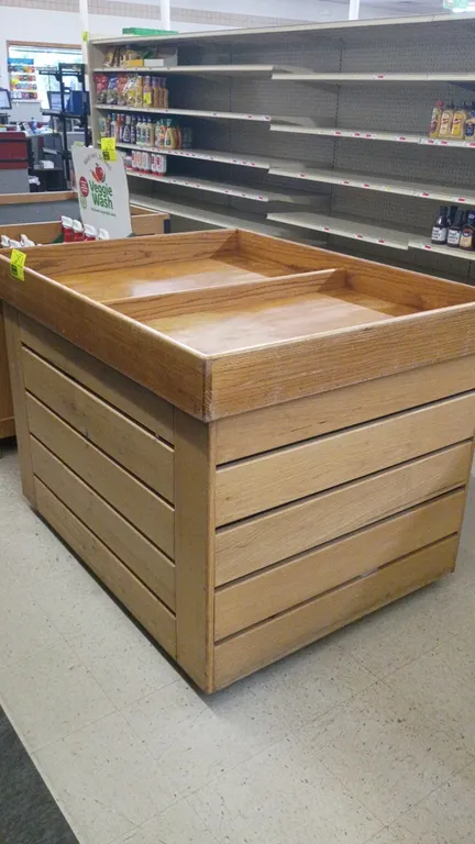 Wooden dump display table. Features a divided top display tray with center partition and slatted wood side panel construction. Dimensions: 50"x39"x37"
